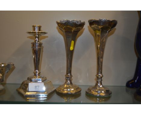 A pair of silver spill vases; and a single silver candlestick