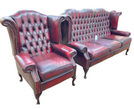 Ox blood leather button backed and studded three seater wing settee and armchair.