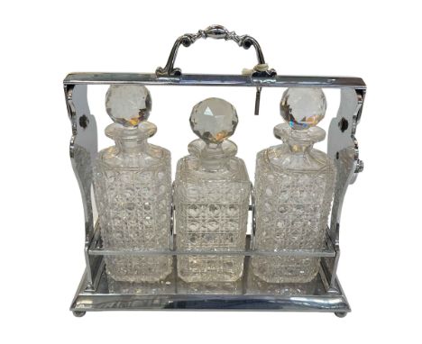 Silver plated three bottled tantalus, 34cm.