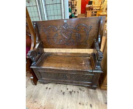 Carved oak Monks bench with lion arms, 70cm by 106cm by 46cm (closed).