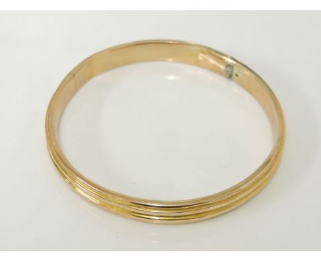 A 9ct gold hollow slave bangle, of ribbed form, damaged, 13.4g