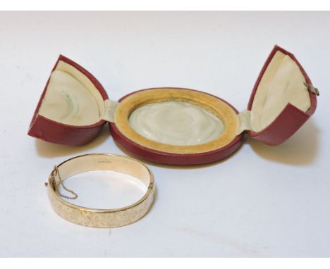A 9ct gold hinged bangle, with engraved decoration, in red canvas box, 16.0g