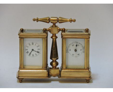 A small brass combination carriage clock and barometer, flanking a turned 'T' bar handle, 10.5cm