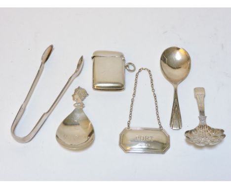 A Georgian silver caddy spoon, two further silver caddy spoons, a silver vesta case, a decanter label, and a pair of silver s