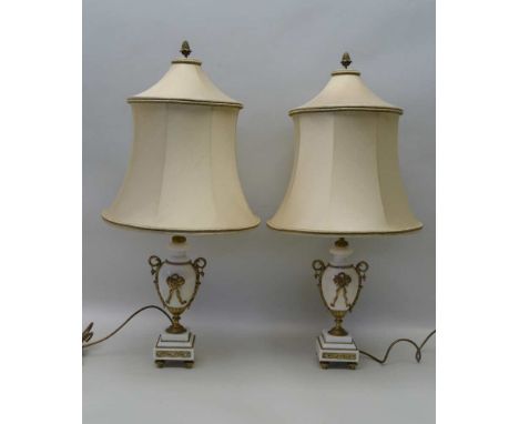 A PAIR OF WHITE MARBLE TABLE LAMPS, with gilt metal mounts, of vase form, raised on stepped square bases, with fabric shades 