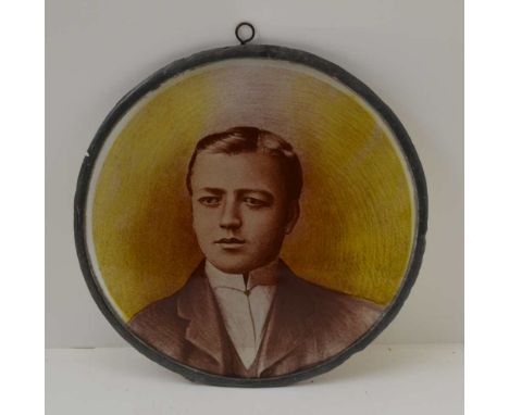 AN EDWARDIAN PAINTED GLASS PANEL, a portrait of a gentleman, circular panel with lead frame and suspension ring, 20cm in diam