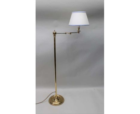 A BRASS READING LIGHT, floor standing with articulated arm, with cream fitted shade Condition report: 1.2m to top of shade, c