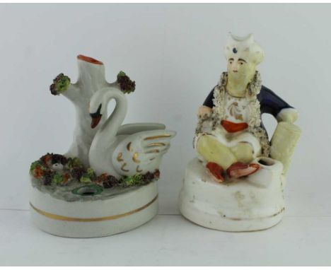 A 19TH CENTURY POTTERY INKWELL in the form of a swan beside her nest, 10cm high, together with a seated pasha inkwell, 12cm h