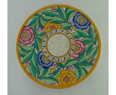 A CHARLOTTE RHEAD POTTERY CHARGER, mottled ground, painted with a floral border and yellow edge, signed en verso, 32cm in dia