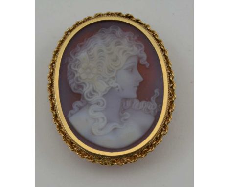 AN OVAL CARVED SHELL CAMEO, depicting a portrait of a young woman in profile, mounted in a 9ct gold frame with brooch pin and