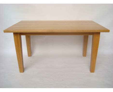 A modern light oak dining table raised on square tapering legs.
150 x 91 x 77cm high. 