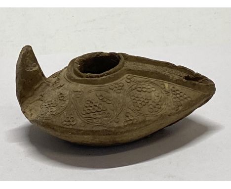 A 12th century Persian Seljuk empire, fired clay oil lamp with grape decoration.