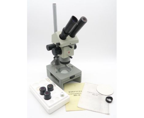 A Russian model MBC-10 stereoscopic microscope, with additional lenses and instruction booklets; together with an earlier cas