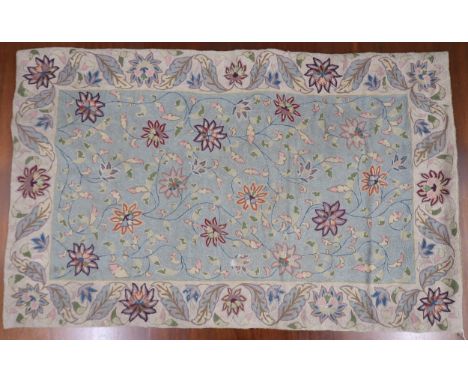 A light blue floral patterned ground Indian wall tapestry with beige flowerhead border, 145cm wide x 92cm high Condition Repo