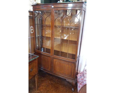 Chippendale style mahogany astragal glazed bookcase with pair doors enclosing shelves, pair panel cupboards below, raised on 