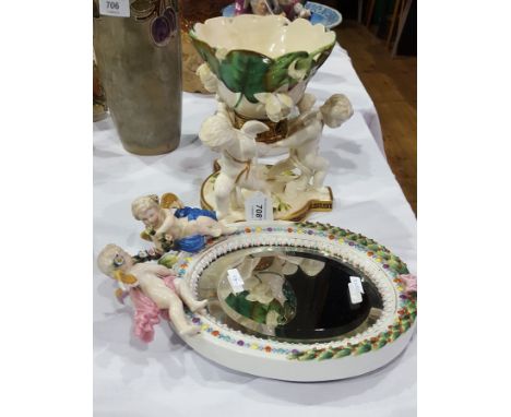 Victorian pottery centrepiece of three putti holding lily leaf and flower decorated raised bowl, on Greek key shaped triangul