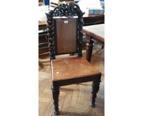 19th century carved walnut hall chair, the crestrail with pierced bird carving, with solid panel back, carved column supports