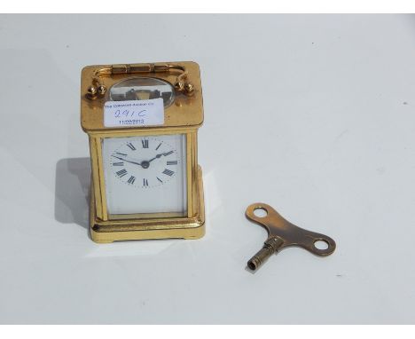 A French carriage clock timepiece in a glazed brass case, the enamelled dial with Roman numerals and swing carrying handle, h