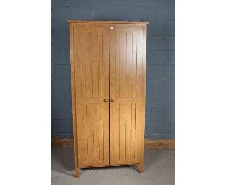 Pair of light oak wardrobes, with hinged doors opening to reveal a single shelf and a rail, 191cm high