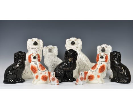 A collection of Staffordshire seated dogs, to include a white version with traditional embellishments and chain and separated