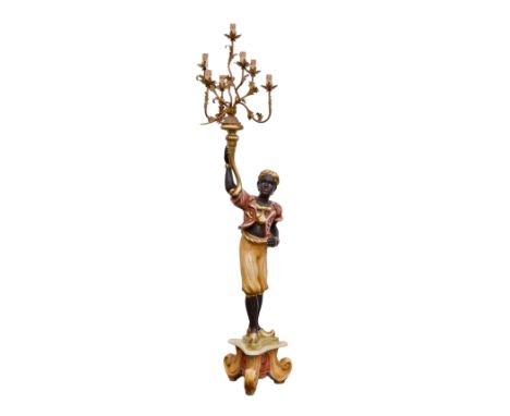 A 19th century painted and parcel gilt blackamoor style floor standing candelabra, second half 20th century, the figure holdi