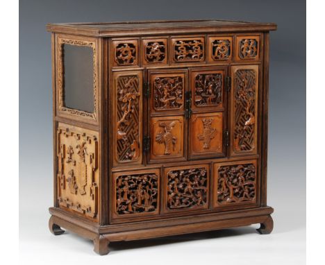 A Chinese carved hardwood table cabinet, probably 19th century, the panelled top over a pierced five panel frieze with dragon