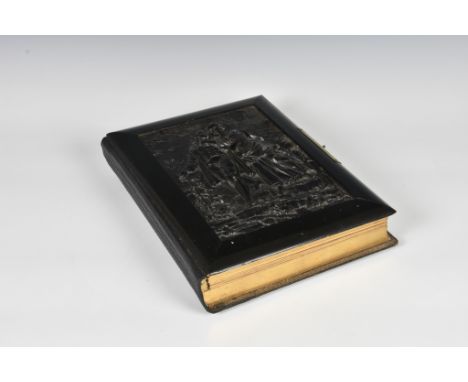 An impressive Victorian vulcanite musical drawing room photograph album, the front cover with high relief carved decoration o