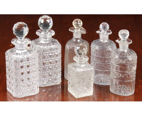 A pair of Georgian oval pint decanters, with panel, diamond and prismatic cut bodies and necks with scalloped, pouring rims, 