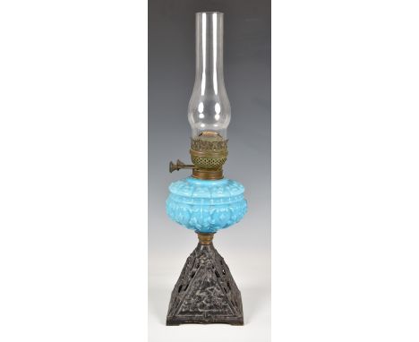 A antique oil lamp with a blue milk glass reservoir, and metal base, 22in., (55.9cm.) high. 