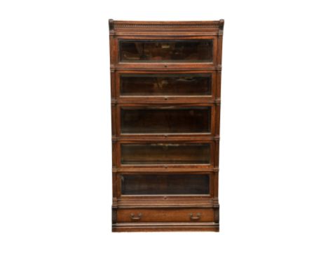 An early 20th century Globe Wernicke modular oak bookcase, the moulded top over a dentil cornice flanked by carved acanthus, 