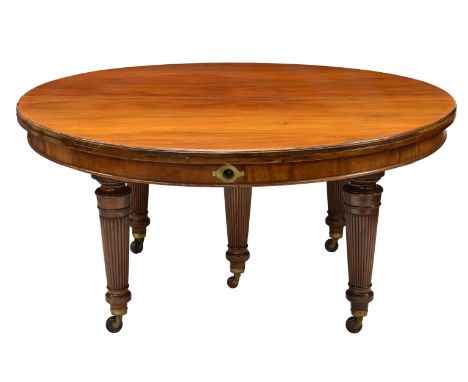 A fine late Victorian mahogany circular extending dining table with leaf holder by Edwards and Roberts, the moulded top over 