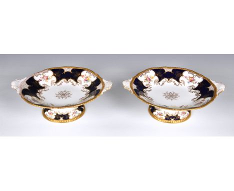 A pair of English Coalport tazzas, of shaped circular form with twin moulded handles, royal blue and white ground with reserv