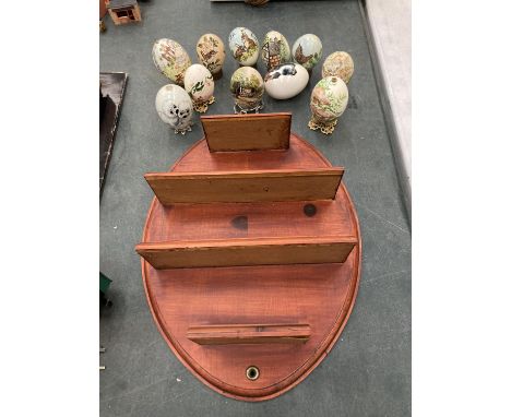 A WOODEN DISPLAY SHELF WITH A QUANTITY OF PAINTED EGGS 