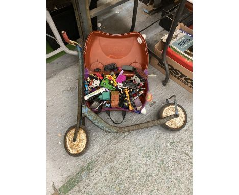 A VINTAGE CHILD'S SCOOTER AND A 'TRUNKI' CONTAINING TRUCKS, CARS, TRAINS, ETC 