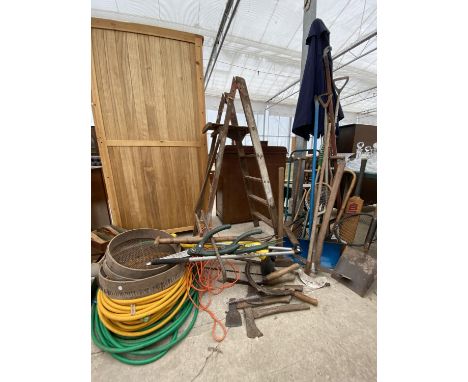 A LARGE ASSORTMENT OF GARDEN TOOLS TO INCLUDE SHOVELS, PICK AXE, WOODEN STEP LADDER AND RIDDLES ETC 