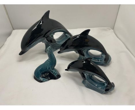 FOUR POOLE POTTERY ANIMALS TO INCLUDE THREE DOLPHINS OF GRADUATING SIZES AND A SEAL, ALL MARKED TO THE BASE AND IN GOOD CONDI