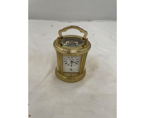 A SMALL VINTAGE STYLE CARRIAGE CLOCK WITH BEVELLED GLASS TO REVEAL THE INNER WORKINGS.  COMPLETE WITH KEY 
