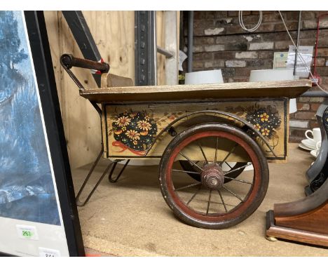 A WOODEN AND METAL VINTAGE CART WITH A HANDPAINTED FLORAL DESIGN COULD BE USED AS A GARDEN PLANTER 