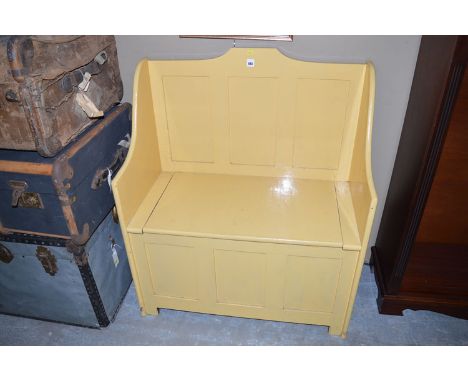 A yellow painted hall bench with lift-up lid,