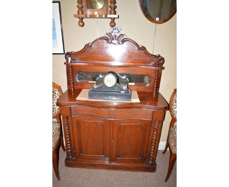 A small Victorian mahogany chiffonier, the back panel with shaped top, a single shelf and a mirror, the shelf supported by tu