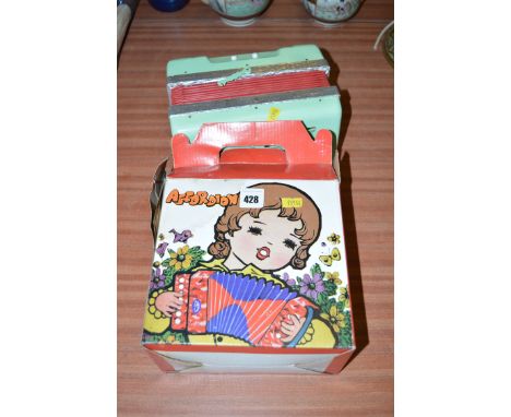 A child's accordion, in original box, 'Made in China'; and another child's piano accordion.