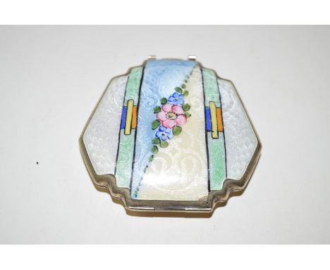 A Art Deco enamelled white metal compact, with painted floral design above engine turned guilloche enamelling and fitted inte