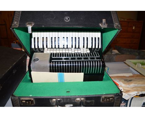 A Hohner electrobox piano accordion in case.