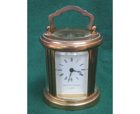 SMALL BRASS OVAL CARRIAGE CLOCK BY MATTHEW NORMAN