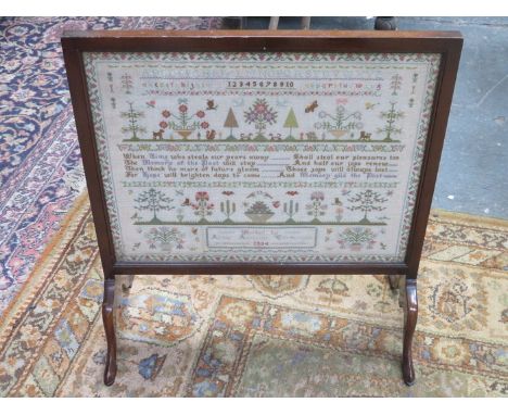 MAHOGANY FIRESCREEN WITH MOUNTED AND GLAZED SAMPLER, DATED 1934 