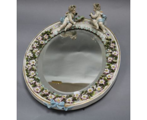 A ceramic floral and putti encrusted wall mirror length 42cm