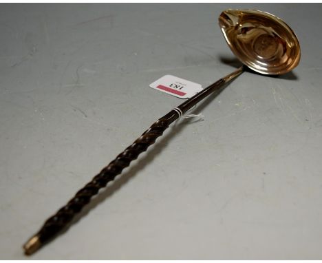 A 19th century white metal toddy ladle, having Georgian coin inset bowl and on turned whalebone handle 