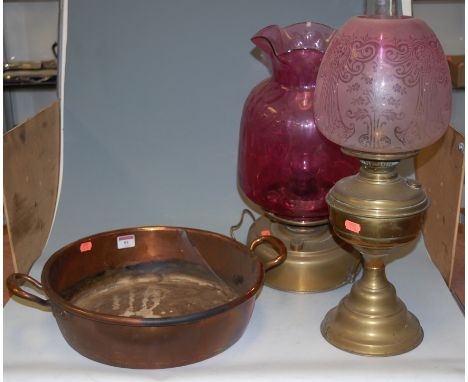 A Victorian brass preserve pan stamped Maple & Co London; a lacquered brass pedestal oil lamp; and one other with cranberry s