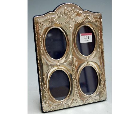 A reproduction silver and embossed easel photograph frame