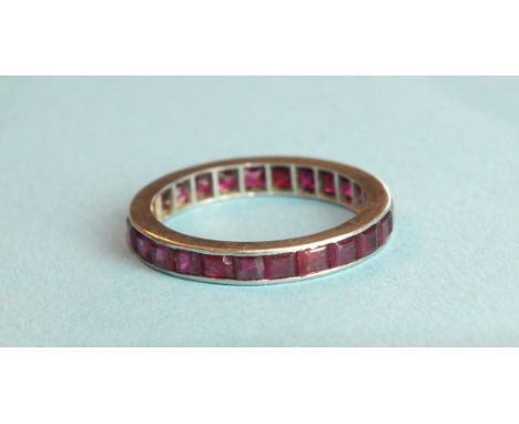 A ruby full-eternity ring set with calibre-cut rubies, in unmarked white metal mount, size M, 2.6g.